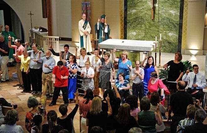 Following the closing prayer, members of the Faith and Light Community at St. Ann gather in front of the altar to sign and sing their community song together. Photo by Lee Depkin