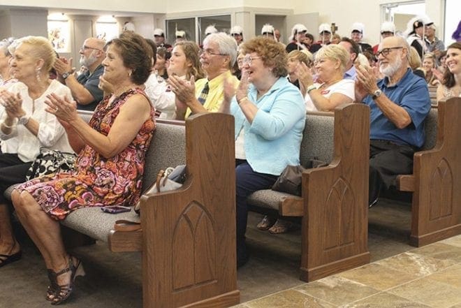 The St. Anna Church congregation applauds their pastor, Father Daniel Toof, for all his efforts to make the new church a reality. Photo By Michael Alexander