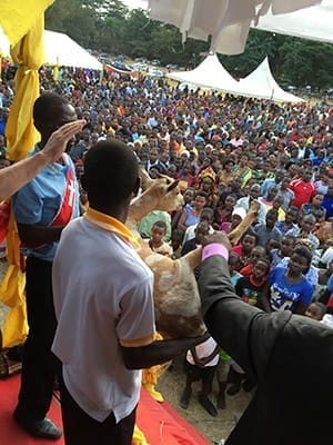 Rally leaders hold an animal to be blessed during a Renewal Ministries program held near the shore of Lake Victoria. After the blessings, animals were sold to raise money for offerings. Between 2,000 and 6,000 people attended the programs to focus on bringing the Gospel to the people.