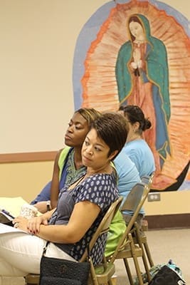 (Foreground to background) Joann Balcita and Nkechi Ijomah-Holmes, second year and new hire preschool teachers, respectively, at St. Thomas the Apostle Church, Smyrna, listen to a workshop presenter talk about tested and proven ideas for keeping toddlers and 2-year-olds engaged. Photo By Michael Alexander