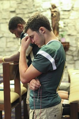 Conner Whelan, a senior running back at Holy Spirit Preparatory School, Atlanta, joins his teammates and football players and coaches from Blessed Trinity High School, Roswell, and St. Pius X High School, Atlanta, in praying the glorious mysteries of the rosary at St. Jude the Apostle Church, Sandy Springs. Photo By Michael Alexander