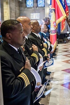 Atlanta fire chiefs hold their hands over their hearts during the presentation of the colors by the Atlanta Police Department honor guard. The Archdiocese of Atlanta hosted its first Blue Mass for public safety officials and first responders at the Cathedral of Christ the King, Atlanta, Sept. 11. Photo By Thomas Spink