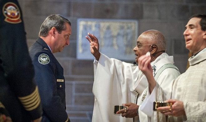 Atlanta Police Department Maj. Van Hobbs, left, receives a blessing from Archbishop Wilton D. Gregory during holy Communion at the Sept. 11 Blue Mass at the Cathedral of Christ the King, Atlanta. Photo By Thomas Spink