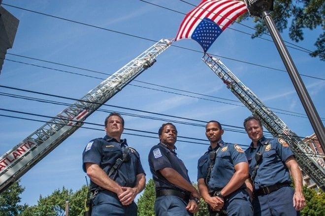 (L-r) Capt. David Bohatch and Justin Walton from Atlanta Fire Station 21 and Brenton Small and Fred Calicone from Station 12 raised the ladders on their stations' apparatus to display the American flag in memory of those fallen on 9/11. Photo By Thomas Spink