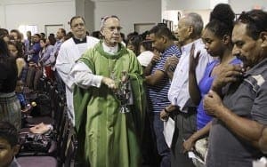 Seguido por el dicono y maestro de ceremonias Joe Pupo de St. Thomas Aquinas Church en Alpharetta, el Obispo Luis Zarama camina bendiciendo con agua bendita a la congregacin. Foto de Michael Alexander