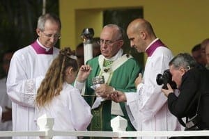 Pope Francis gives Communion to a girl during Mass in Havana Sept. 20. Five Cuban children received their first Communion from the pope during the service in Havana's Revolution Square. CNS photo/Claudia Daut, Reuters