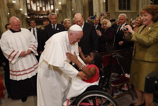 Pope Francis embraces a woman in a wheelchair as he arrives to celebrate vespers in St. Patrick's Cathedral in New York Sept. 24. CNS Photo/Paul Haring