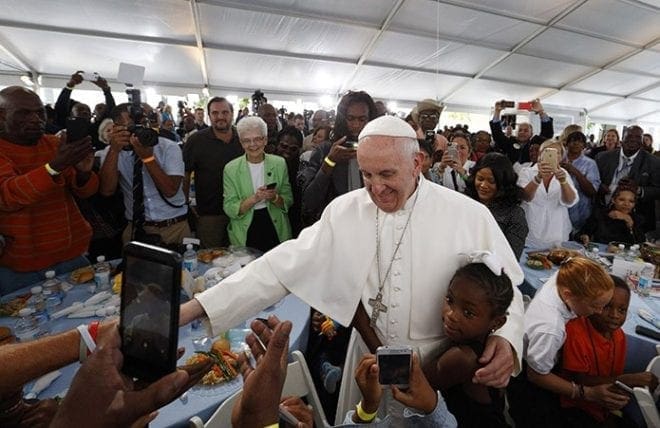 A girl hugs Pope Francis as he visits with people at St. Maria's Meals Program of Catholic Charities in Washington Sept. 24. CNS Photo/Paul Haring