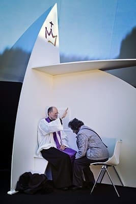 A priest blesses a woman as he hears confession during a 2013 outdoor Mass in Madrid. Pope Francis has issued a letter offering a series of instances in which absolution can be granted during the Year of Mercy. CNS photo/Emilio Naranjo, EPA