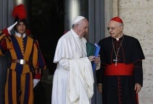 Pope Francis talks with Cardinal Lorenzo Baldisseri, general secretary of the Synod of Bishops, as he leaves a session of the synod at the Vatican Oct. 24.
