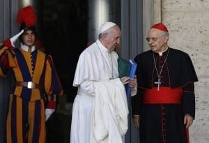 Pope Francis talks with Cardinal Lorenzo Baldisseri, general secretary of the Synod of Bishops, as he leaves a session of the synod at the Vatican Oct. 24. 