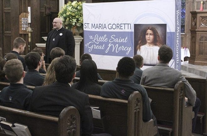 Standing in the sanctuary of Holy Spirit Church, Atlanta, and prior to the public viewing and veneration of the major relics of St. Maria Goretti, Companions of the Cross Father Carlos Martins gives an Oct. 26 presentation about the Catholic Church’s youngest canonized saint to high school students from Holy Spirit Preparatory School. Photo By Michael Alexander