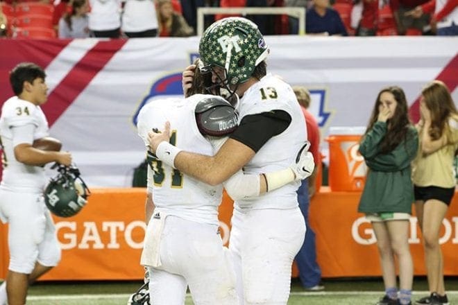 Blessed Trinity High School senior quarterback Conor Davis, right, and his younger brother Ryan, a freshman wide receiver, console one another along the sidelines following the team’s 38-31 overtime loss to Westminster during the Class AAA state football championship at the Georgia Dome. Photo By Michael Alexander