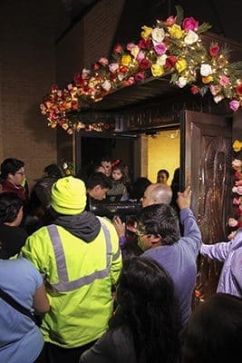 Father Carlos Bustamante, parochial vicar at Our Lady of the Americas Mission, uses a megaphone to request the large crowd to enter the Holy Door of Mercy in a calm and orderly fashion. Photo By Michael Alexander