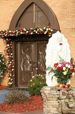 The afternoon sunlight illuminates the statue of Our Lady of Guadalupe and the Holy Door at Our Lady of the Americas Mission, Lilburn. Photo By Michael Alexander