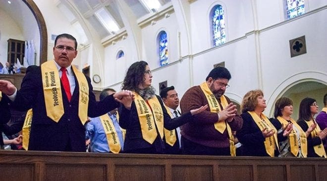 Class members hold hands during the Mass celebrated as part of the graduation event. During their three-year program, they received encouragement and spiritual formation, as well as completed 90 weeks of study, 18 books and 90 discussion forums, videos and exams. Photo By Thomas Spink