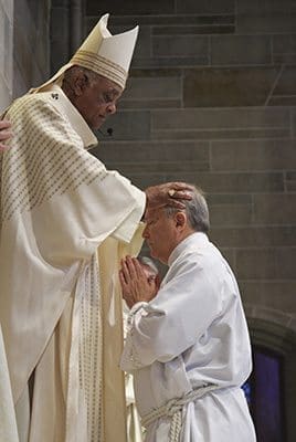 Archbishop Wilton D. Gregory lays hands upon diaconate ordination candidate Robert Perri of Prince of Peace Church, Flowery Branch. Photo By Michael Alexander