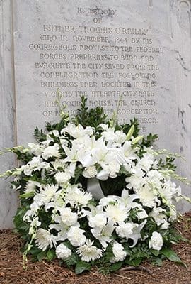 Frank McGing, president of the Hibernian Benevolent Society of Atlanta, and Shane Stephens, consul general of Ireland, placed a wreath at the Father Thomas O’Reilly memorial on the northwest grounds of Atlanta City Hall March 11 as the heroic feats of the Irish priest and former pastor of the Shrine of the Immaculate Conception were remembered in a memorial ceremony. Photo By Michael Alexander