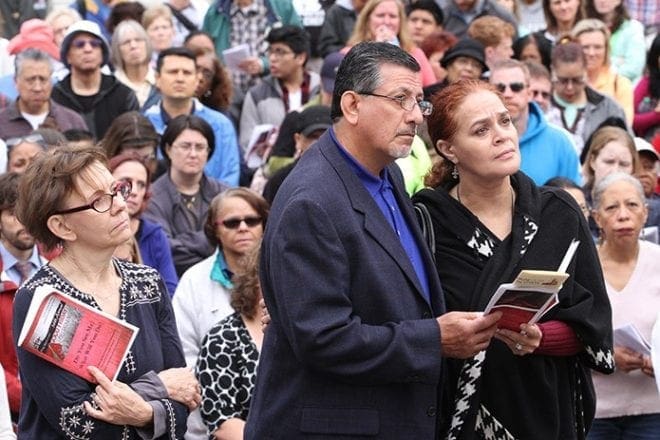 Michael and Dee Hidalgo, foreground right, of St. Francis of Assisi Church, Cartersville, listen to a reflection during the second Station of the Cross (Jesus takes up his cross) based on the theme of homelessness. Attending the 36th annual Good Friday pilgrimage was a first-time experience for the Hidalgos. Photo By Michael Alexander