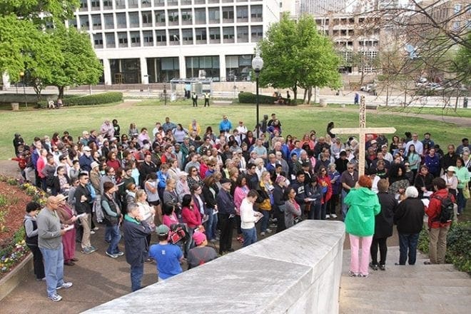 A crowd of close to 200 people assembles in Hurt Park for the sixth Station of the Cross (Veronica wipes the face of Jesus) during the March 25 Good Friday pilgrimage. Photo By Michael Alexander