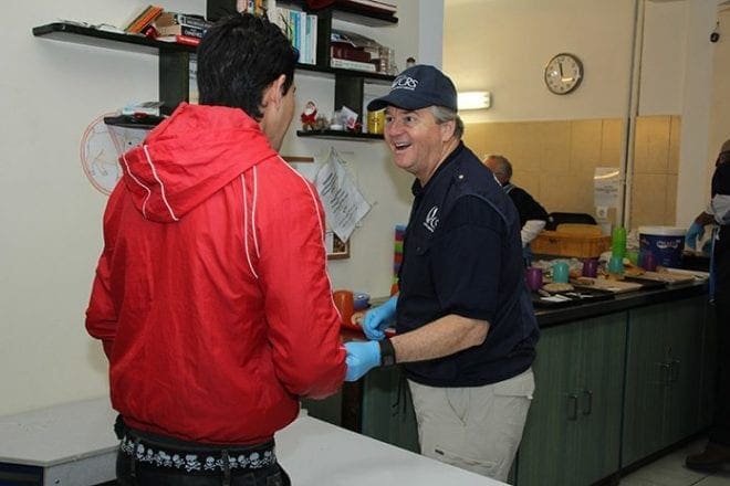 Deacon Steve Swope, of St. George Church, Newnan, traveled in late January to Greece and Serbia to work with refugees along with Catholic Relief Services. He is shown serving food to one of the refugees during his trip. Deacon Swope shared his experiences at the March 3 Refugee Forum held at Holy Trinity Church, Peachtree City. Photo By Mikaele Sansone/Catholic Relief Services