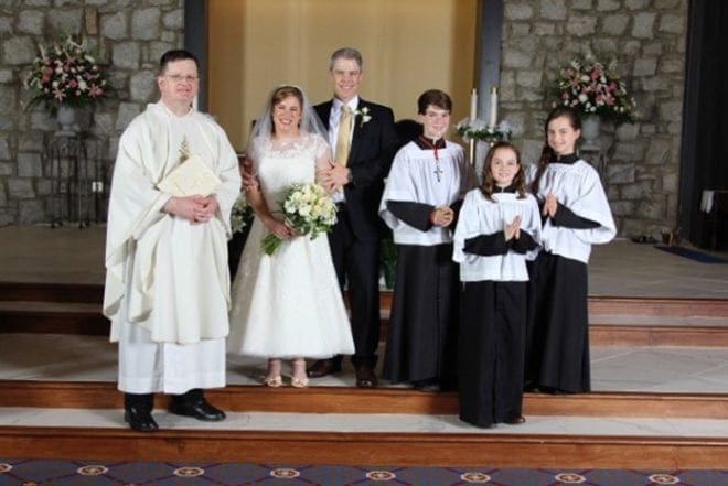 Msgr. Joseph Corbett, left, pastor of St. Jude the Apostle Church, celebrated the nuptial Mass for the Dempseys. Altar servers, left to right, were St. Jude School students Alex Curtin, Jack Curtin and Christina Sweeney. Photo By Lori Darden