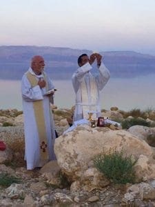 Father Neil Dhabliwala, pastor of St. Luke the Evangelist Church, Dahlonega, celebrates Mass at the Dead Sea. Praying with him is Father Jacques Philippe, a priest of the Community of the Beatitudes.