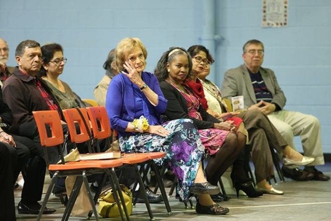 Gini Eagen wipes tears from her eyes as pastor emeritus Claretian Father Greg Kenny talks warmly about Eagen and her 30 years of dedication to the parish. Photo By Michael Alexander