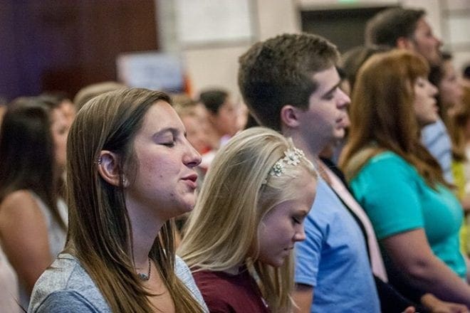 Several hundred young adults, many from area colleges, gathered for a talk, music and prayer at the REVIVE track June 3. Speaker Doug Tooke told them to keep following the path to the altar and “share the good news.” Photo By Thomas Spink