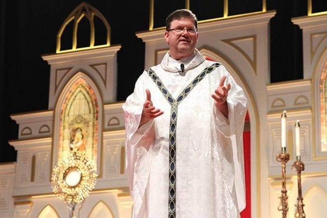 Father Tim Hepburn, archdiocesan director of vocations, addresses the congregation during exposition of the Blessed Sacrament at the healing service held June 3 at the Eucharistic Congress. Father Hepburn led the healing service with Father Jorge Carranza, parochial vicar at Good Shepherd Church, Cumming. Photo By Michael Alexander