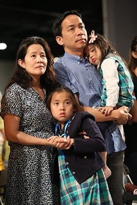 (Clockwise, from top right) Phillip Tran, his 3-year-old daughter Philomena, his 8-year-old daughter Felicita and his wife Racheal, attend the June 3 opening Mass for the 2016 Eucharistic Congress at the Georgia International Convention Center, College Park. They are parishioners at the Holy Vietnamese Martyrs Church in Norcross. Photo By Michael Alexander