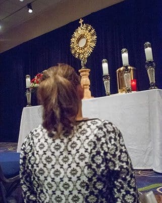 A woman takes time to stop in the adoration chapel for a moment of prayer before the Blessed Sacrament. The chapel is open throughout the congress. Photo By Thomas Spink
