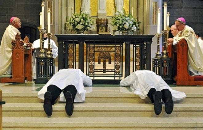 Ordination candidates (l-r) Brian McNavish and Bradley Starr prostrate themselves before the altar at the Cathedral of Christ the King, Atlanta, during the litany of supplication. The men were ordained transitional deacons May 28. Photo By Lee Depkin