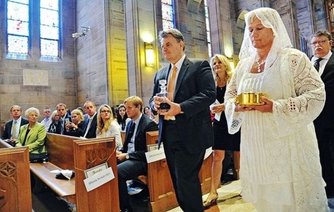 Parents of the candidates at the ordination May 28 bring the gifts to the altar. Shown are David McNavish, center, with his wife Carol behind him, and Jean Baylot, right, with Laurence Starr behind her. Photo By Lee Depkin
