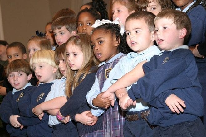 In this January 2004 photo St. Thomas More School kindergarten students (l-r, front row) Michael Pate, Liam Stieffel, Noah Stephens, Kendell Hutchison, Maia Harrell, Andrew Rochefort and Sam deCocq sing the civil rights anthem, "We Shall Overcome" during the Dr. Martin Luther King Jr. Youth & Young Adult Celebration at the Shrine of the Immaculate Conception, Atlanta. Photo By Michael Alexander