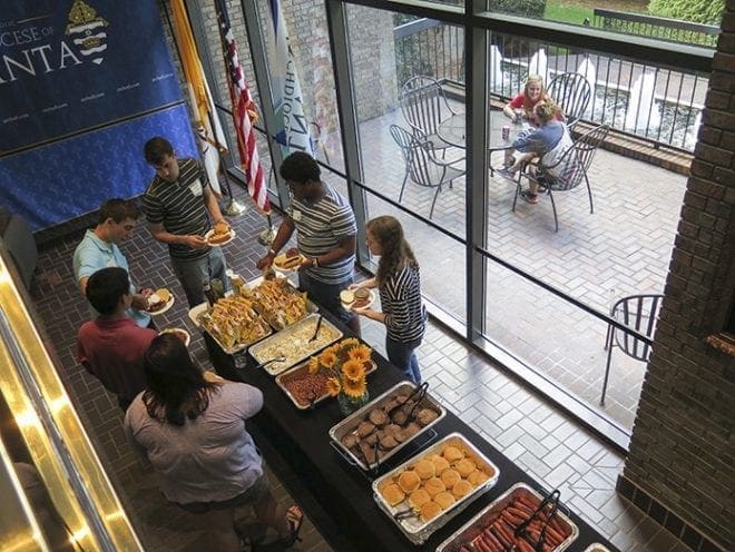 All of the On the Deck gatherings begin with a meal. After dinner people gather to sing praise and worship songs and participate in the program, which centers on foundational Christianity. Some 60 young adults have been attending the Tuesday evening sessions. Photo By Mary Anne Castranio