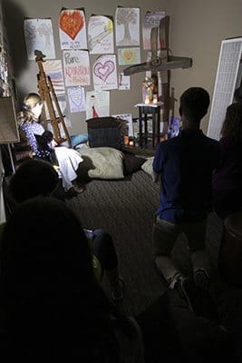 Teens and adult volunteers pray before the Blessed Sacrament in a small room off the studio devoted to adoration. Photo By Michael Alexander