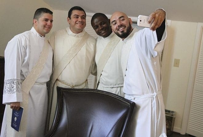 To suppress any pre-ordination jitters, candidates (l-r) Roberto Suarez Barbosa, Gerardo Ceballos, Valery Akoh and Carlos Cifuentes take a group “selfie” minutes before the liturgical ceremony. Photo By Michael Alexander