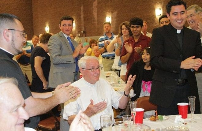 Father Frank Richardson, center, is given a standing ovation at the retirement party held by his parish, Good Shepherd Church. Father Ignacio Morales, right, served at the parish for five years. On the far left is the current parochial vicar, Father Jorge Carranza. The party included a slideshow and many guest speakers, who poked fun at the pastor’s love for golf and Irish beer. Photo By David John Torrento Photography