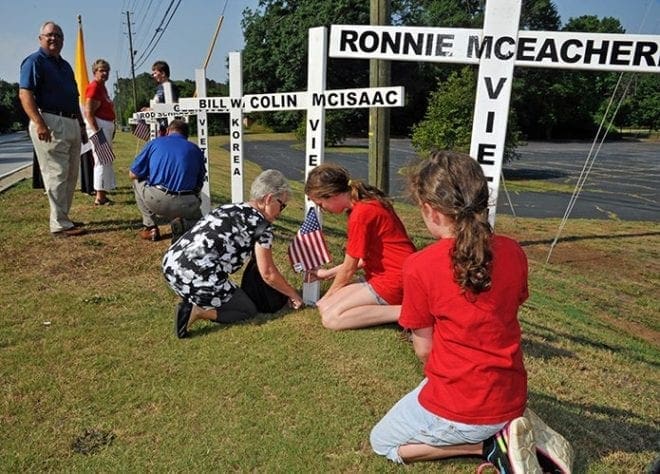 After 8:30 a.m. Mass on July 4, parishioners processed with small American flags and one was placed at each memorial cross by a family member or friend. Over 55 crosses were decorated. Photo By Lee Depkin