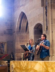 Musicians Greg Ferrara, right, and Geneva Tigue of Holy Trinity Church, Peachtree City, teach pilgrims the official theme song of World Youth Day, “Blessed Are the Merciful.” Photo By Joseph Pham