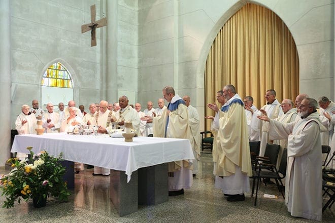 Archbishop Wilton D. Gregory prepares to elevate the bread at the consecration during the Liturgy of the Eucharist as the new abbot Dom Augustine Myslinski, OCSO, stands to the archbishop’s immediate left. Photo By Michael Alexander