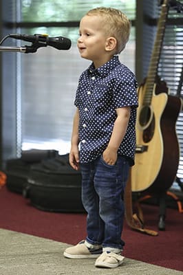 Two-year-old Oliver Tolcher kicked off the Chancery Summer Concert with his rendition of the National Anthem. Oliver is the grandson of Deacon Richard Tolcher, director of Prison and Jail Ministry in the Office of Life, Dignity and Justice. Photo By Michael Alexander