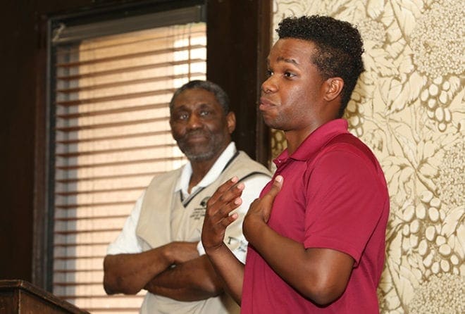Just prior to his May 2016 PGA Tour China, Wesley Yates, foreground, speaks to a crowd of supporters during a fundraising dinner in April at a southwest Atlanta restaurant, organized by St. Anthony of Padua Church parishioner Solomon Brannan Jr., background. Photo By Michael Alexander