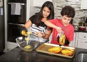 Jackson Kelly, right, and his mother Nour often collaborate on cooking projects in their Dunwoody kitchen. Nour and Jackson’s dad Nick dated for two years at St. Pius X High School, Atlanta, and all four years at UGA before marrying in April 2004. Photo By Michael Alexander