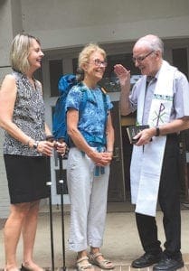 Father David McGuinness, pastor of St. Joseph Church, Athens, blesses Marianne Reeves, left, and Marty Ledenham weeks before the two embark on The Camino de Santiago de Compostela.