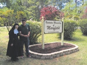Mother Jane Frances Williams of the Monastery of the Visitation in Snellville, the superior of the cloistered monastery, stands with Chad Baker, Eagle Scout, who provided the monastery with a new sign as part of his Eagle Scout project. 