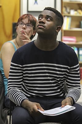 Henry Lubin, foreground, sophomore biology major at Clark Atlanta University, and Teresa Nosacek, a first year graduate student at Georgia State University, view a photograph on the screen above them, depicting the work of CRS in responding to global poverty. Photo By Michael Alexander