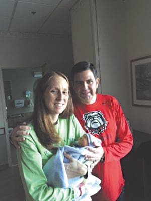 Erika and Brent Herrin of Woodstock hold their son, Matthew Isaac, on Feb. 18, when he was three days old. Despite a severe chromosomal condition, Matthew lived for 15 days, which the family believes was an answer to many prayers. A fund in his memory is endowed for a scholarship to Queen of Angels School, Roswell. Photo Courtesy of the Herrin Family