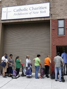 People wait to enter a food pantry at Catholic Charities of the Archdiocese of New York's community center in the South Bronx July 14. Both the Democrats and the Republicans address economic issues in the opening pages of their respective parties' platforms, an indication of how seriously they take economic policy in its potential appeal to voters this election year. CNS photo/Gregory A. Shemitz